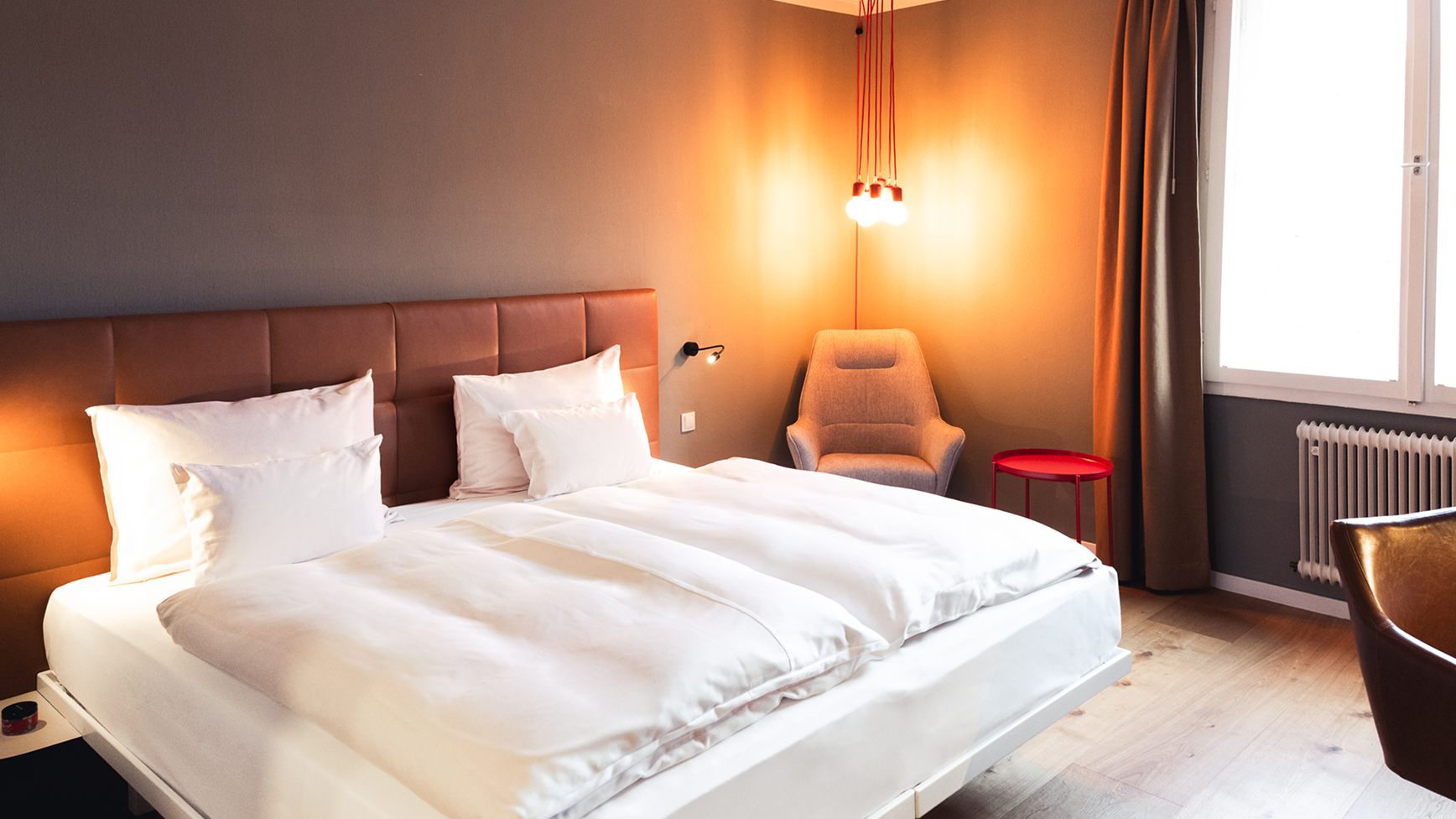 Ein Schlafzimmer mit einem Bett, einem Stuhl und einem Fenster.