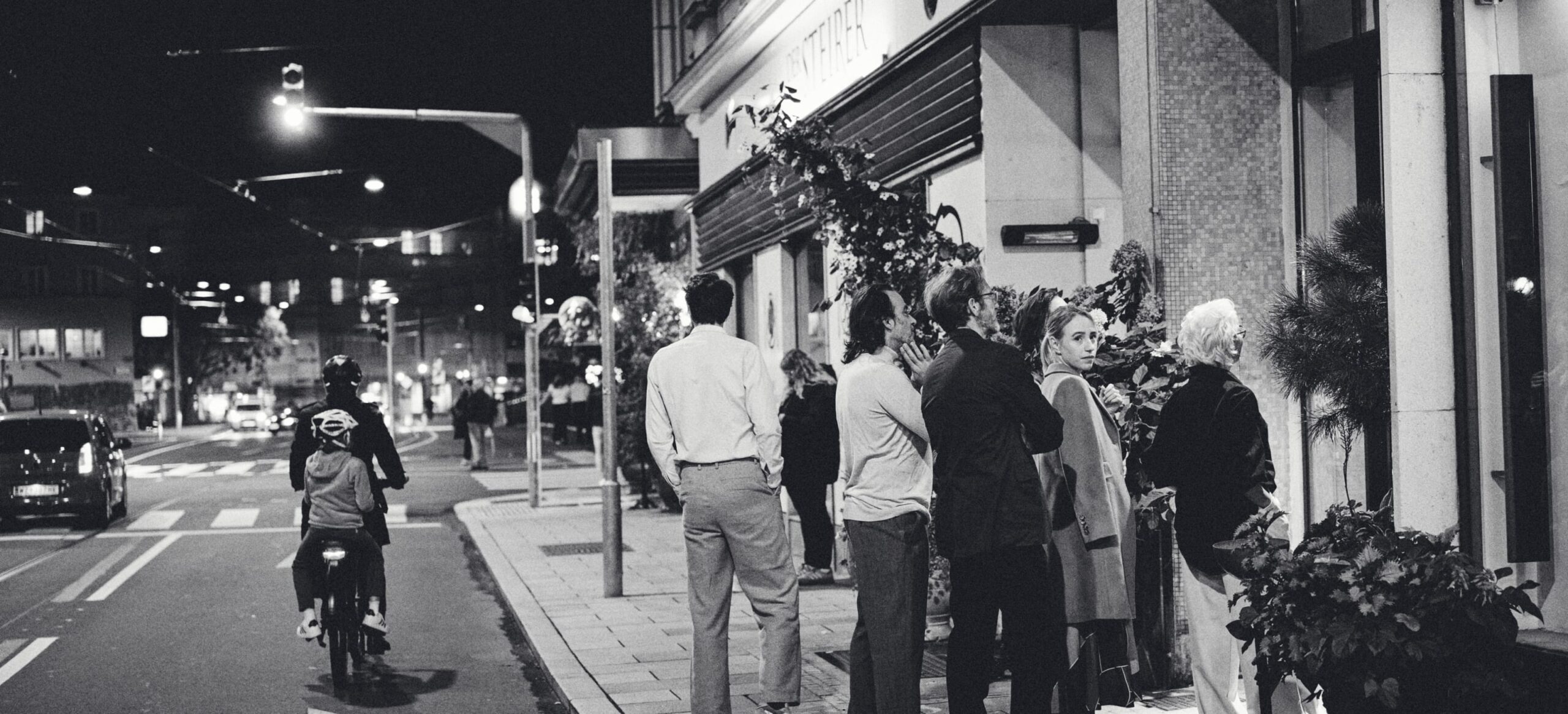 Nachts schauen Leute in ein Schaufenster von Santoni-Schuhe in Mailand.