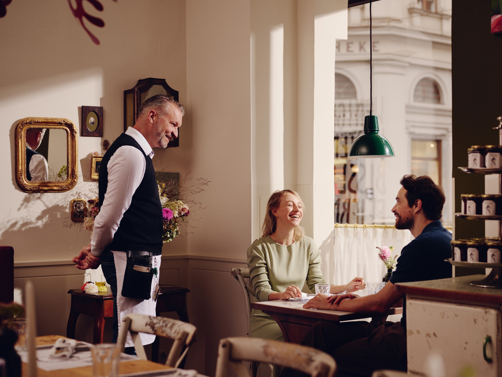 Ein Kellner bedient ein Paar an einem Tisch in einem Restaurant.