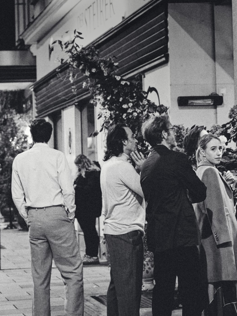 Black and white photo of a crowd in front of the Denksteirer restaurant.