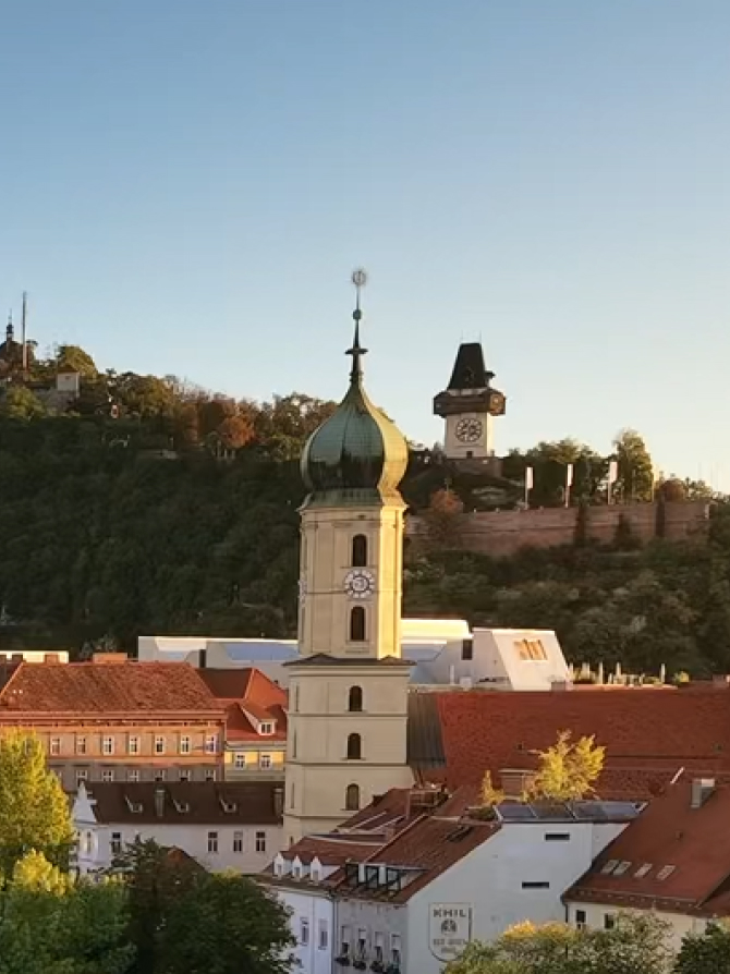 View of Graz, Austria, featuring the Grazer Uhrturm and the Franciscan Monastery.
